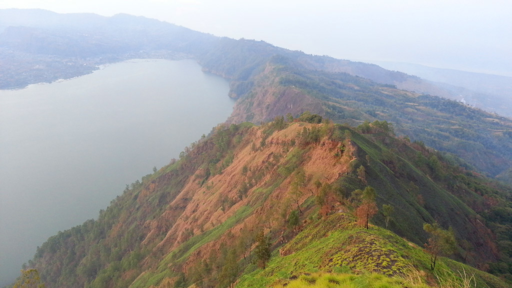 A Batur tó fentről, az azt átölelő kráter tetejéről. Jobbra Bali északi része és az óceán.
