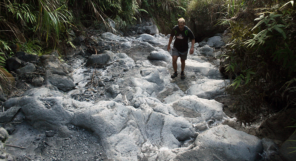 A Lokon vulkánra vezető ösvényen, a megszilárdult lávafolyáson lépkedve